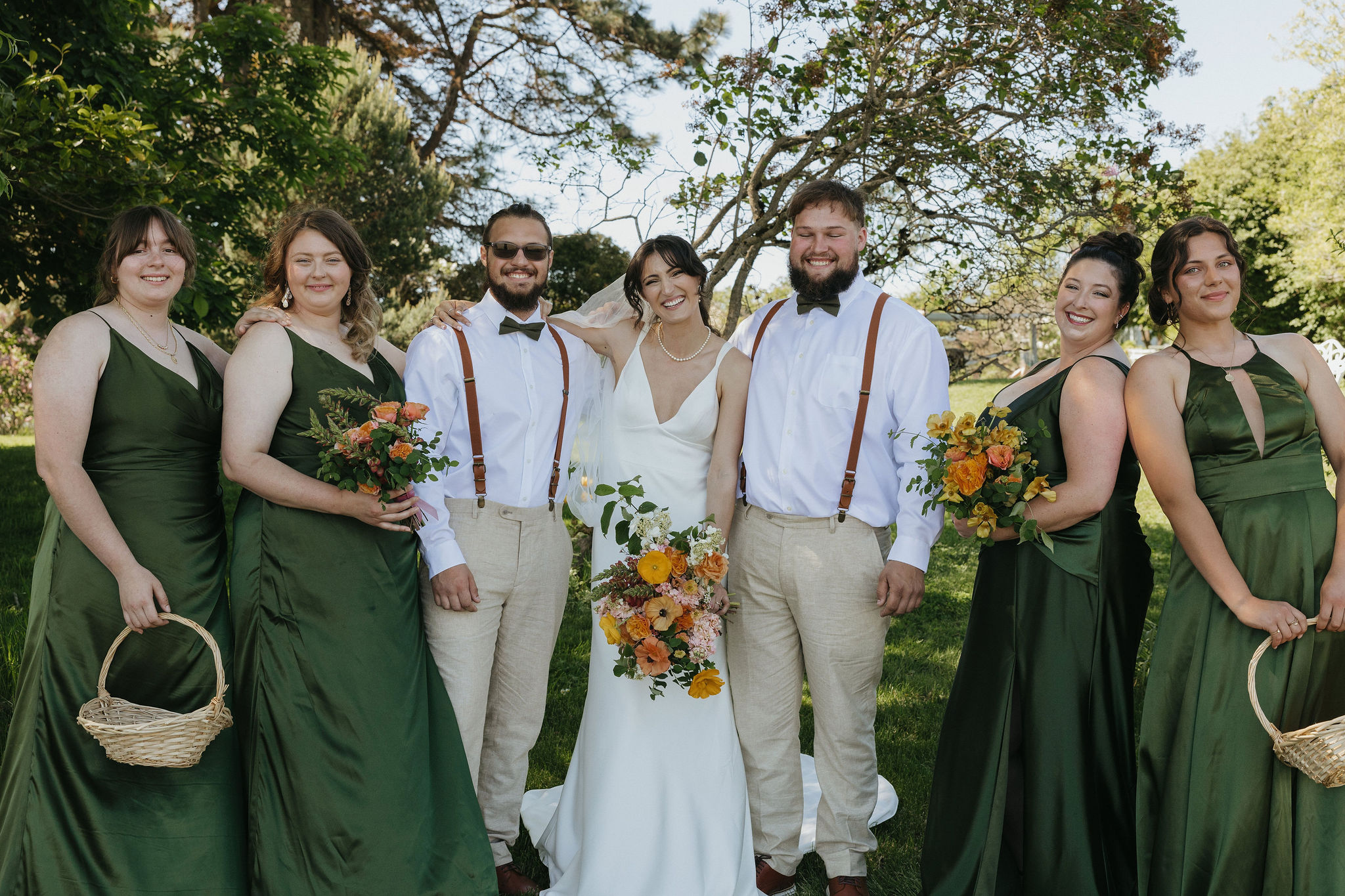 Bride smiling with her bridesmaids and groomsmen