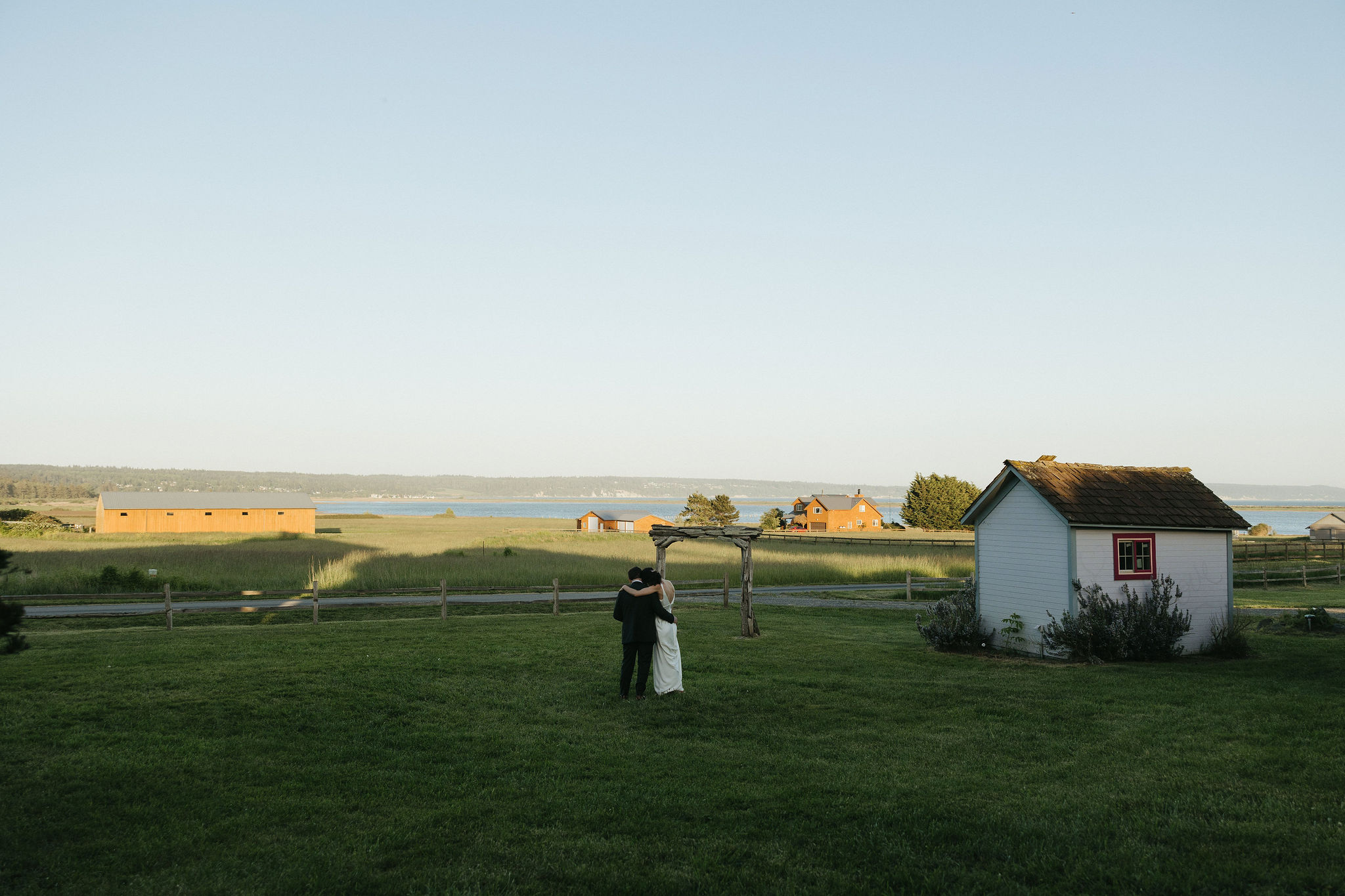 Bride and groom looking off into the distance at Crocket farms at Whidbey island wedding venue