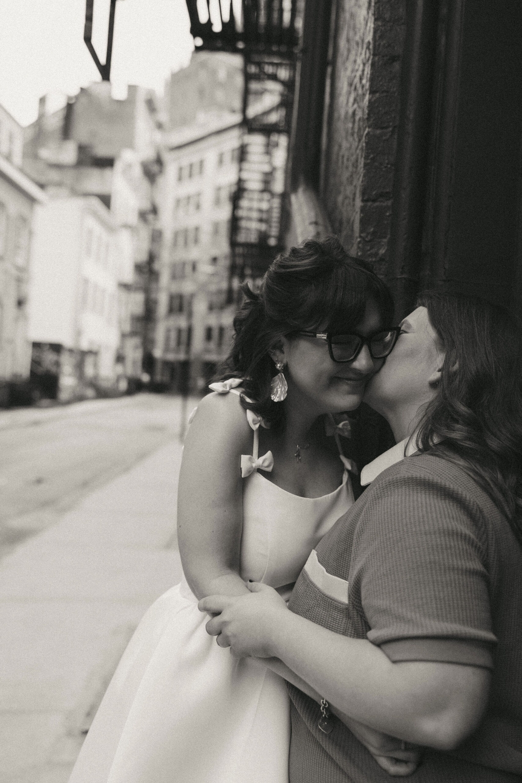 Black and white photo of fiance kissing her soon to be wife on the cheek