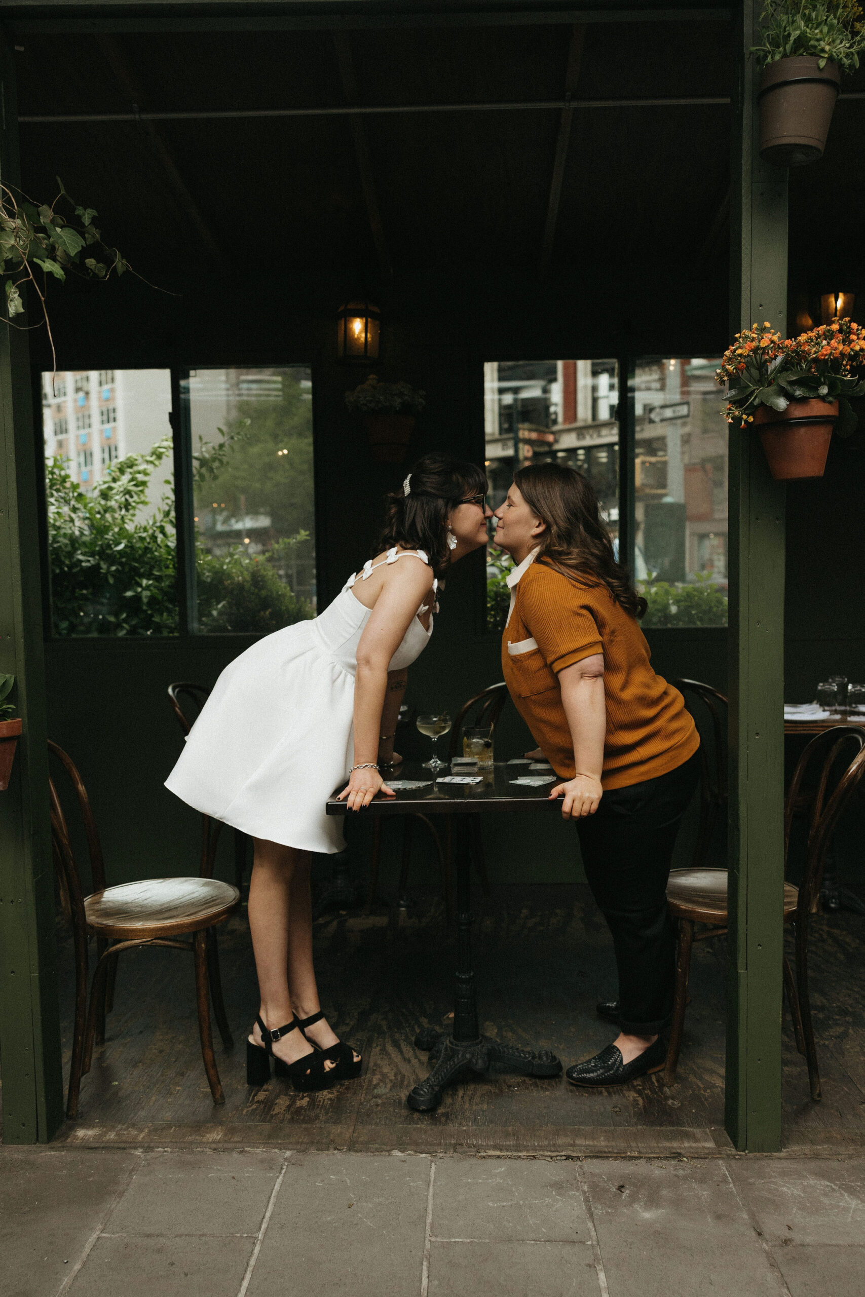 Newly engaged couple kissing at a table at Olio E Più in New York