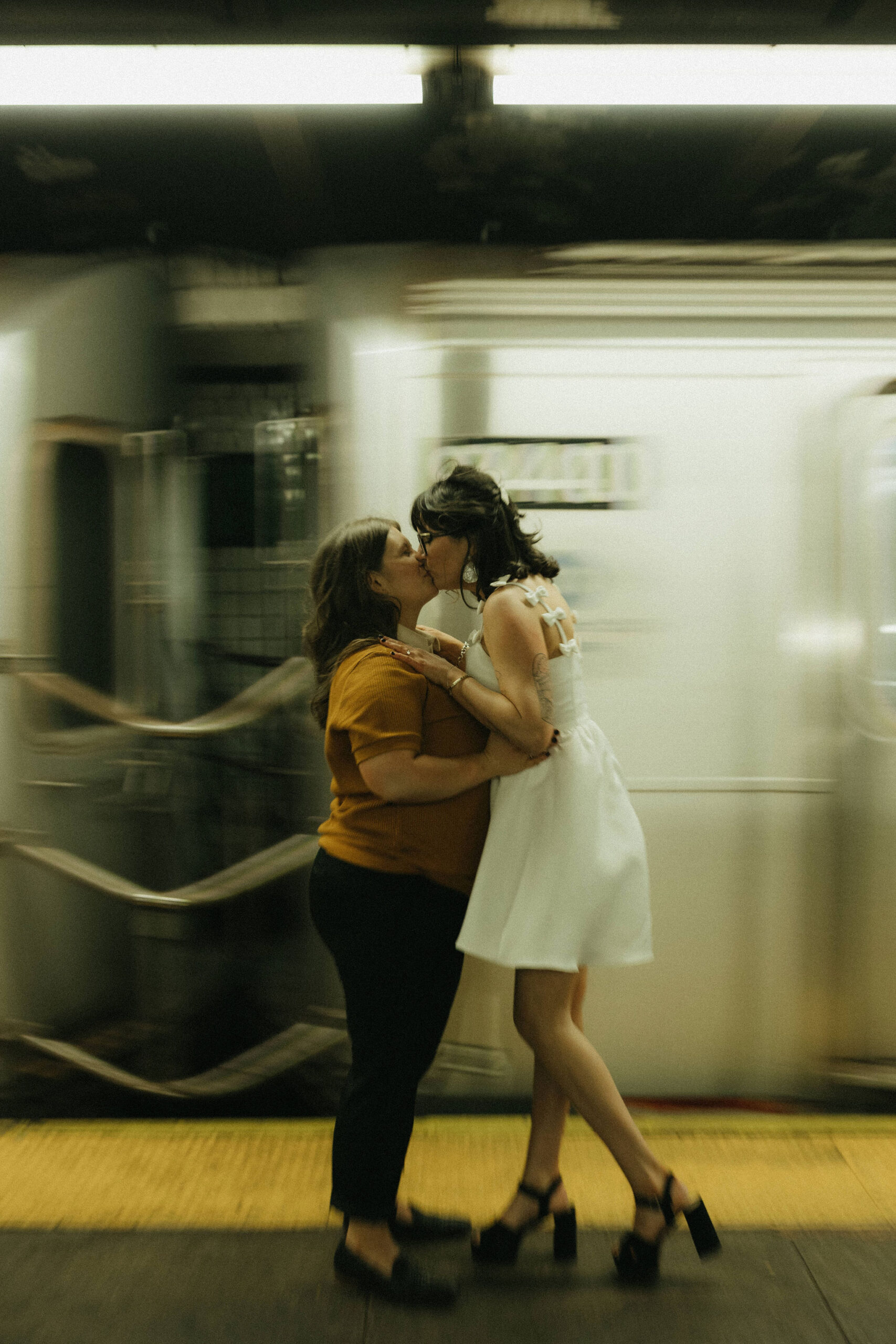 Newly engaged couple kissing in the New York subways for their personalized engagement photography