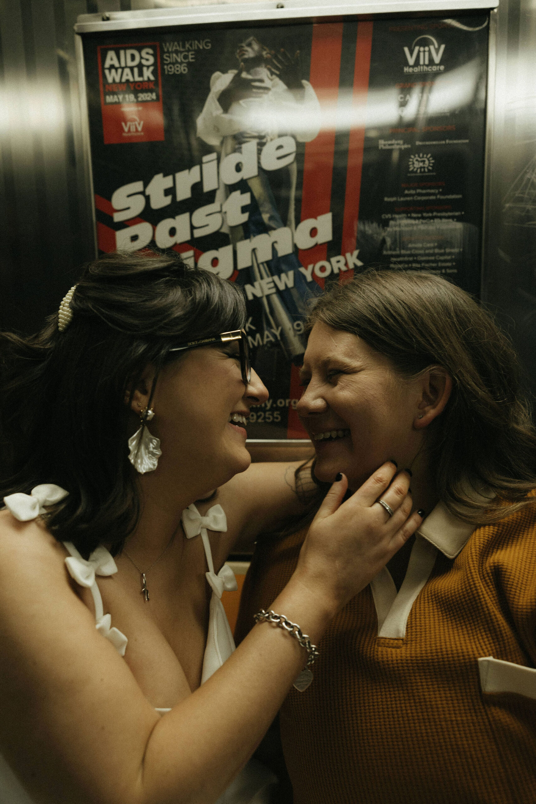 Newly engaged couple sitting laughing in the New York subways for their personalized engagement photography