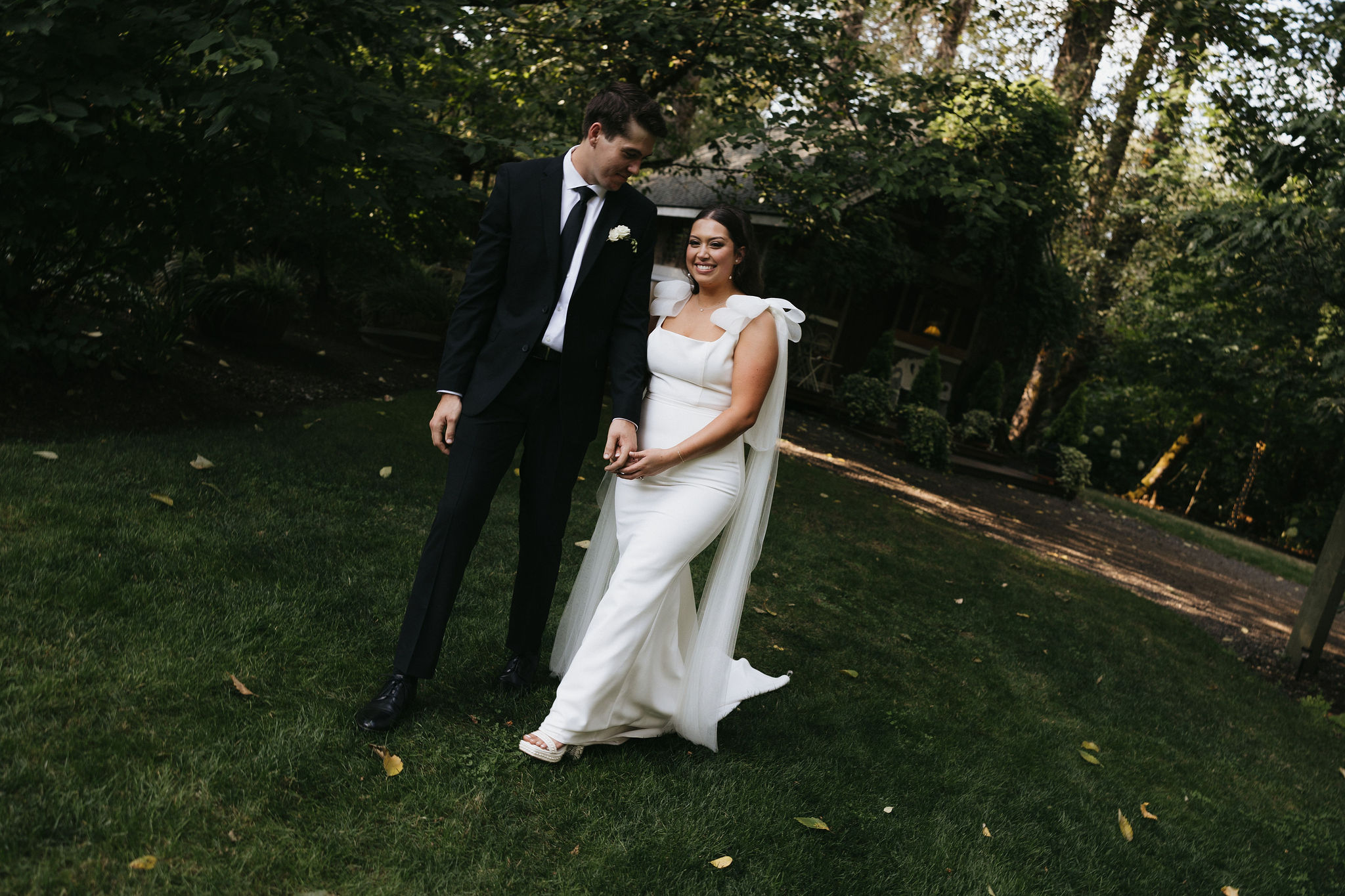 Bride and groom walking in grass at the Maroni meadows wedding venue