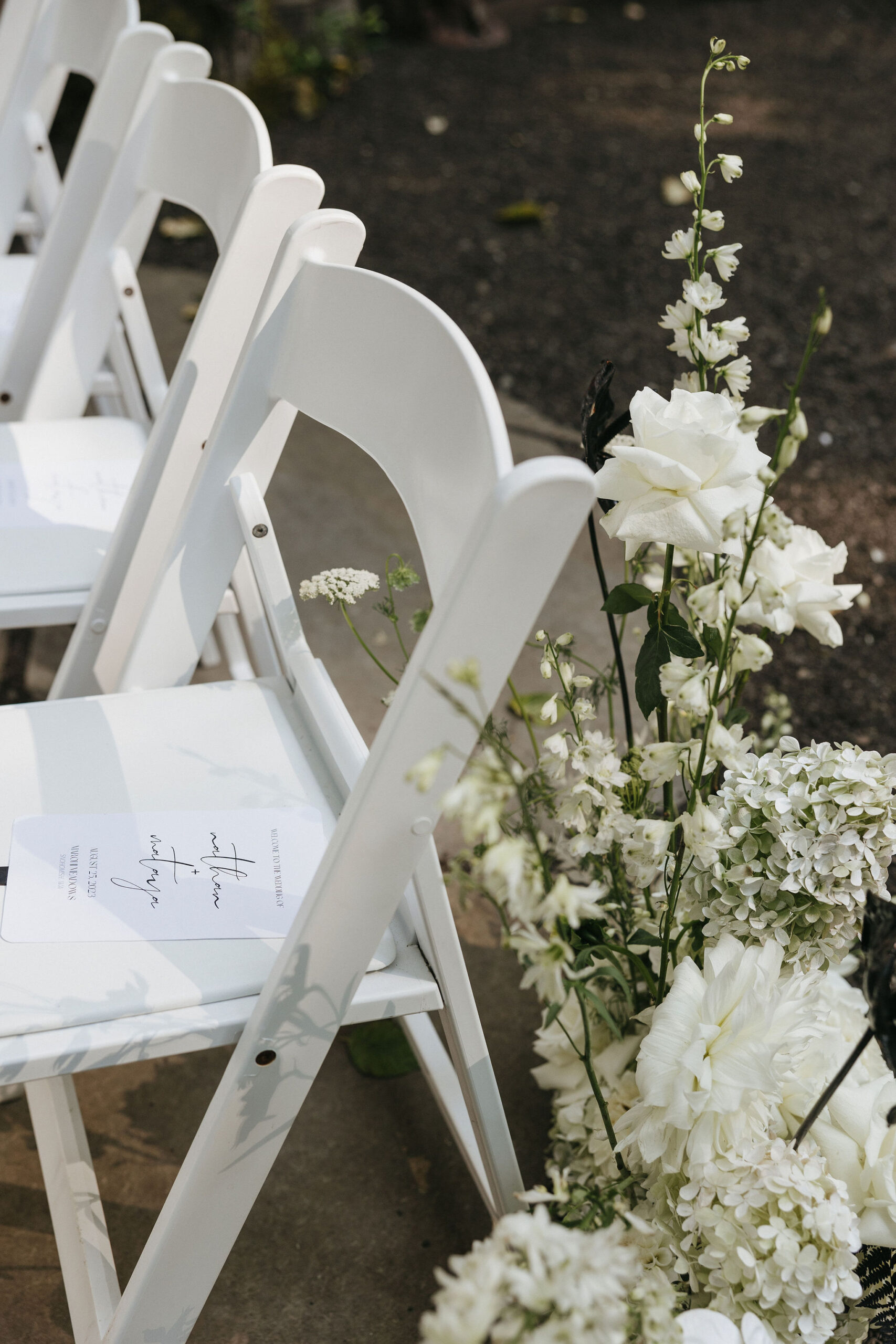 White wedding ceremony seats and florals