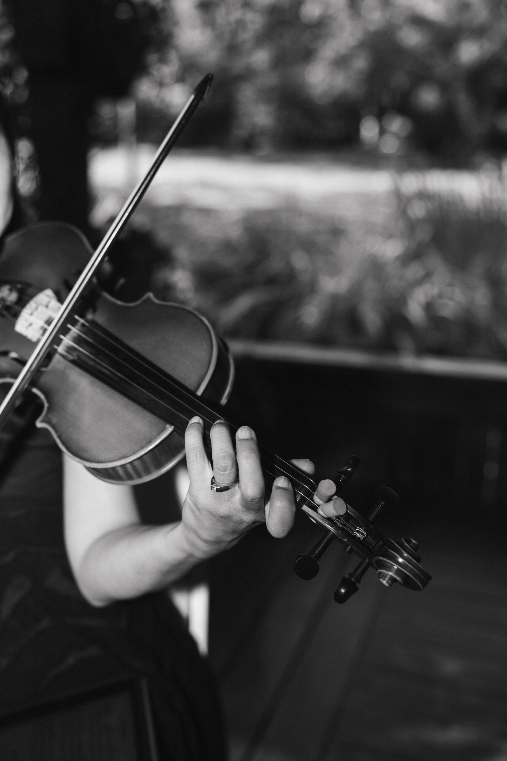 Black and white photo of violinist playing at a wedding ceremony 