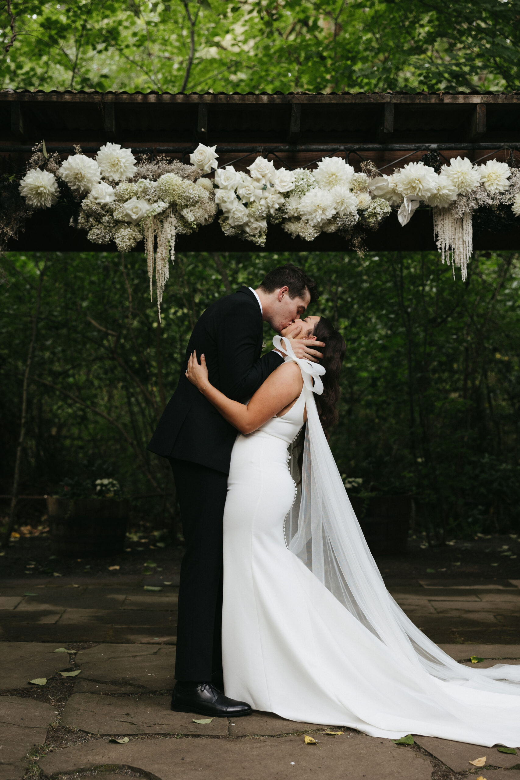 Bride and groom kissing during their wedding ceremony at Maroni Meadows wedding venue