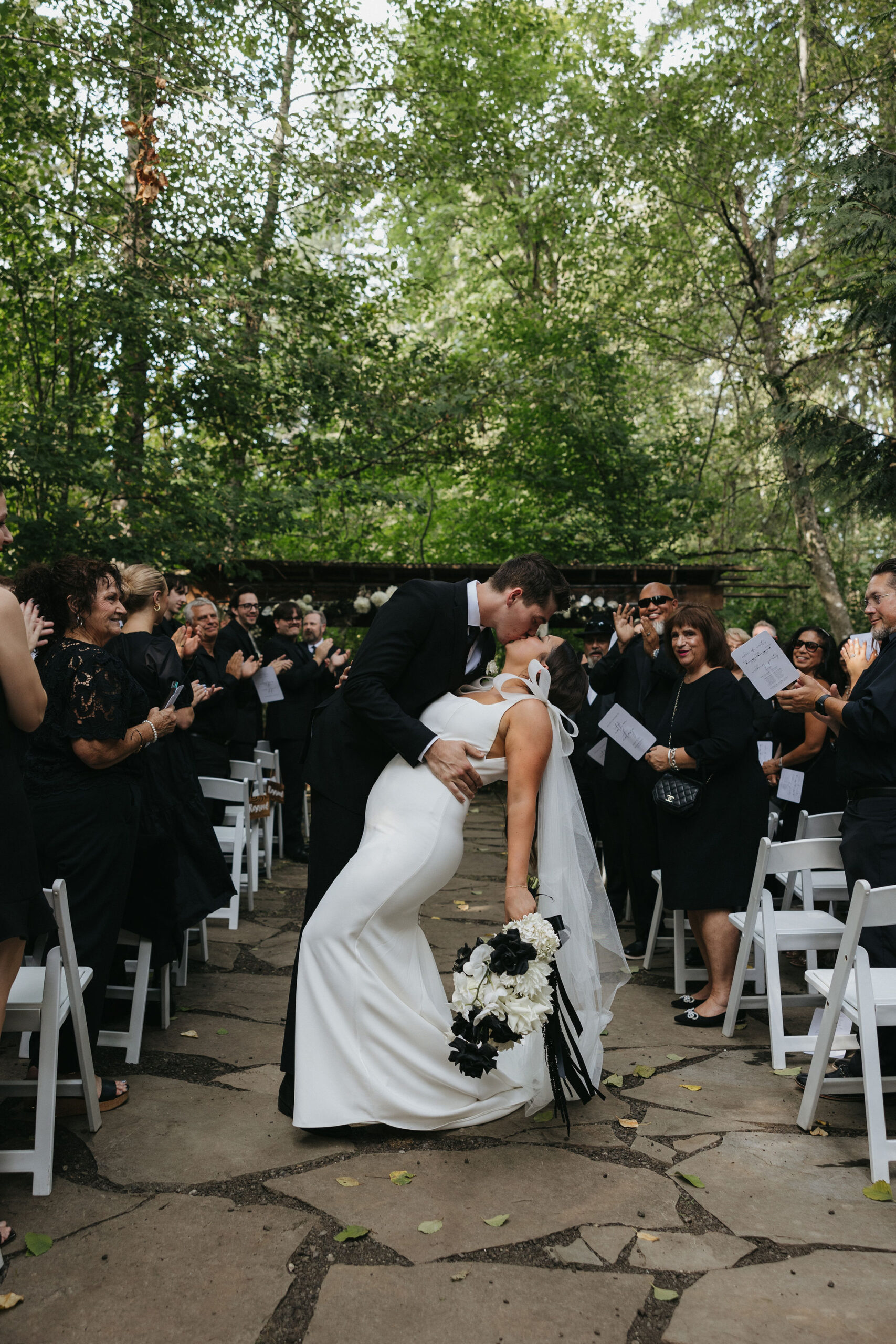 Bride and groom kissing after their wedding ceremony up the aisle