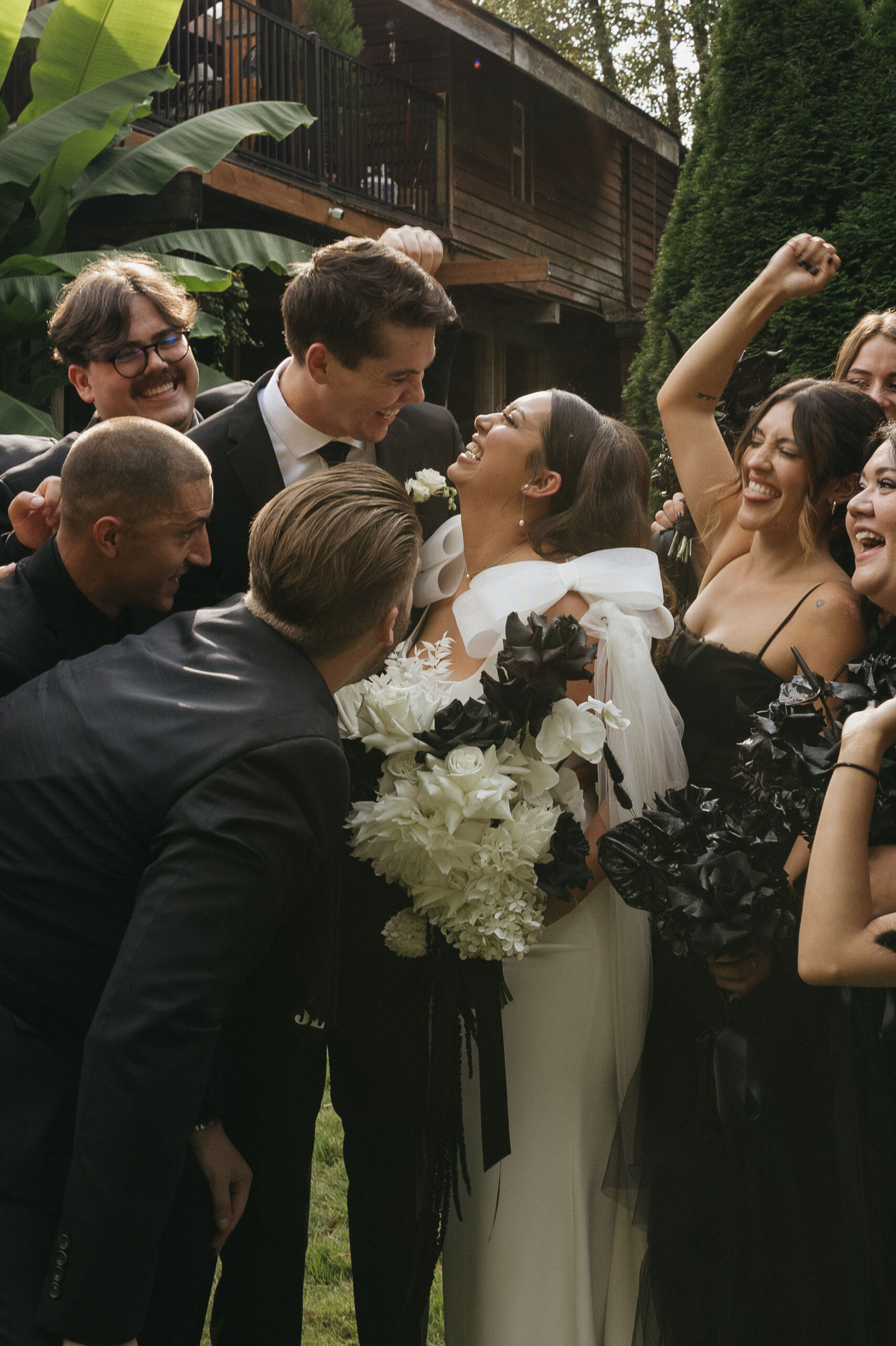 Bride and groom smiling and laughing as their bridal party cheer around them