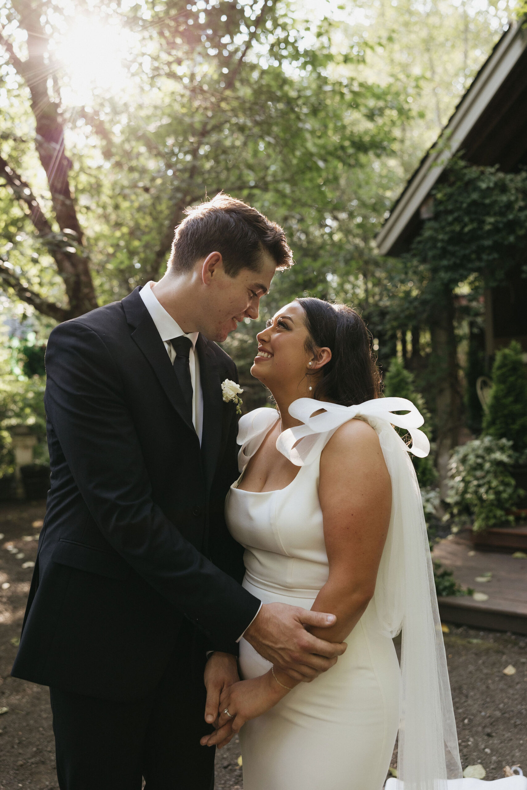 Bride and groom embracing eachother smiling 