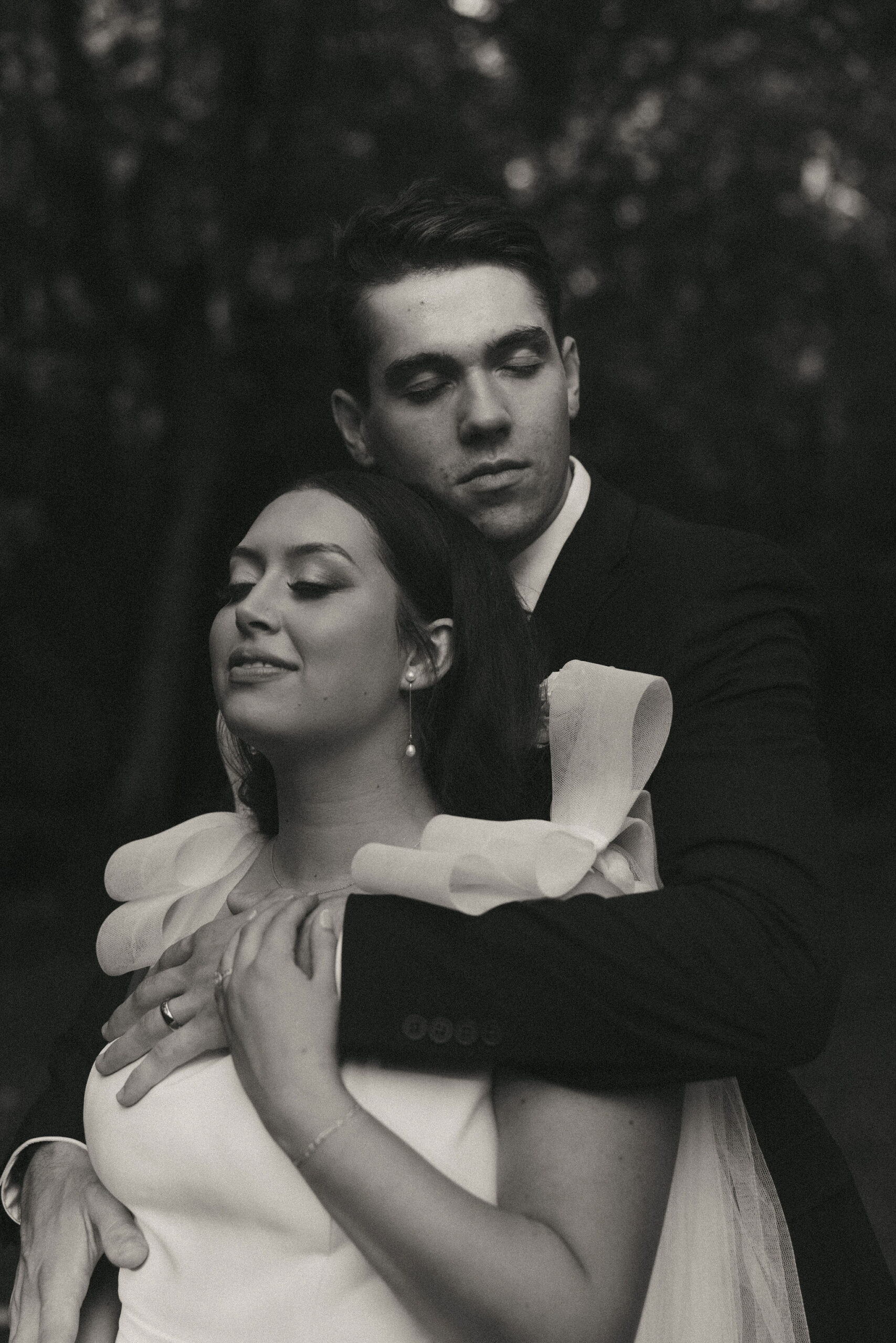 Black and white photo of bride and groom embracing eachother 