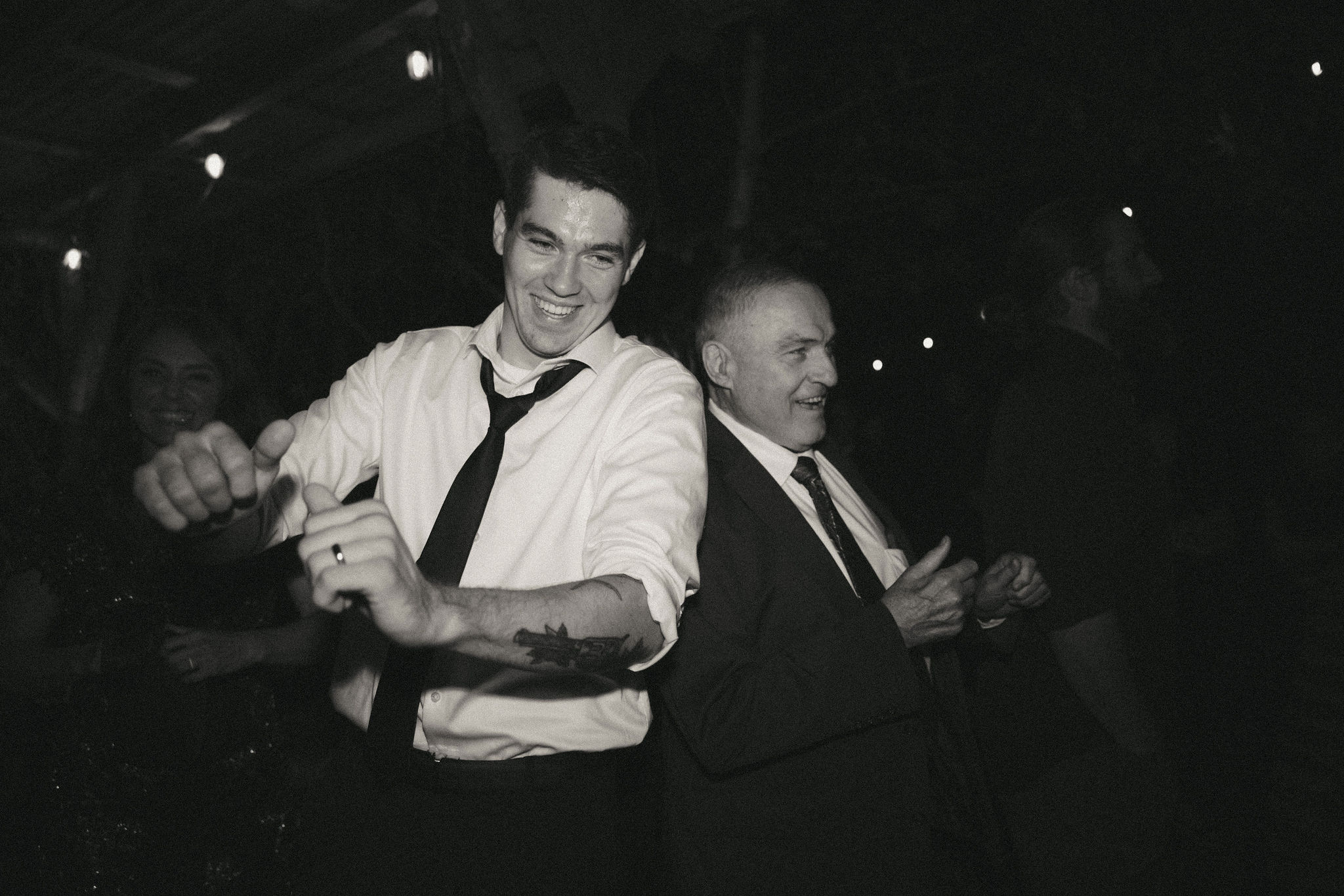 Black and white photo of groom dancing with his dad 