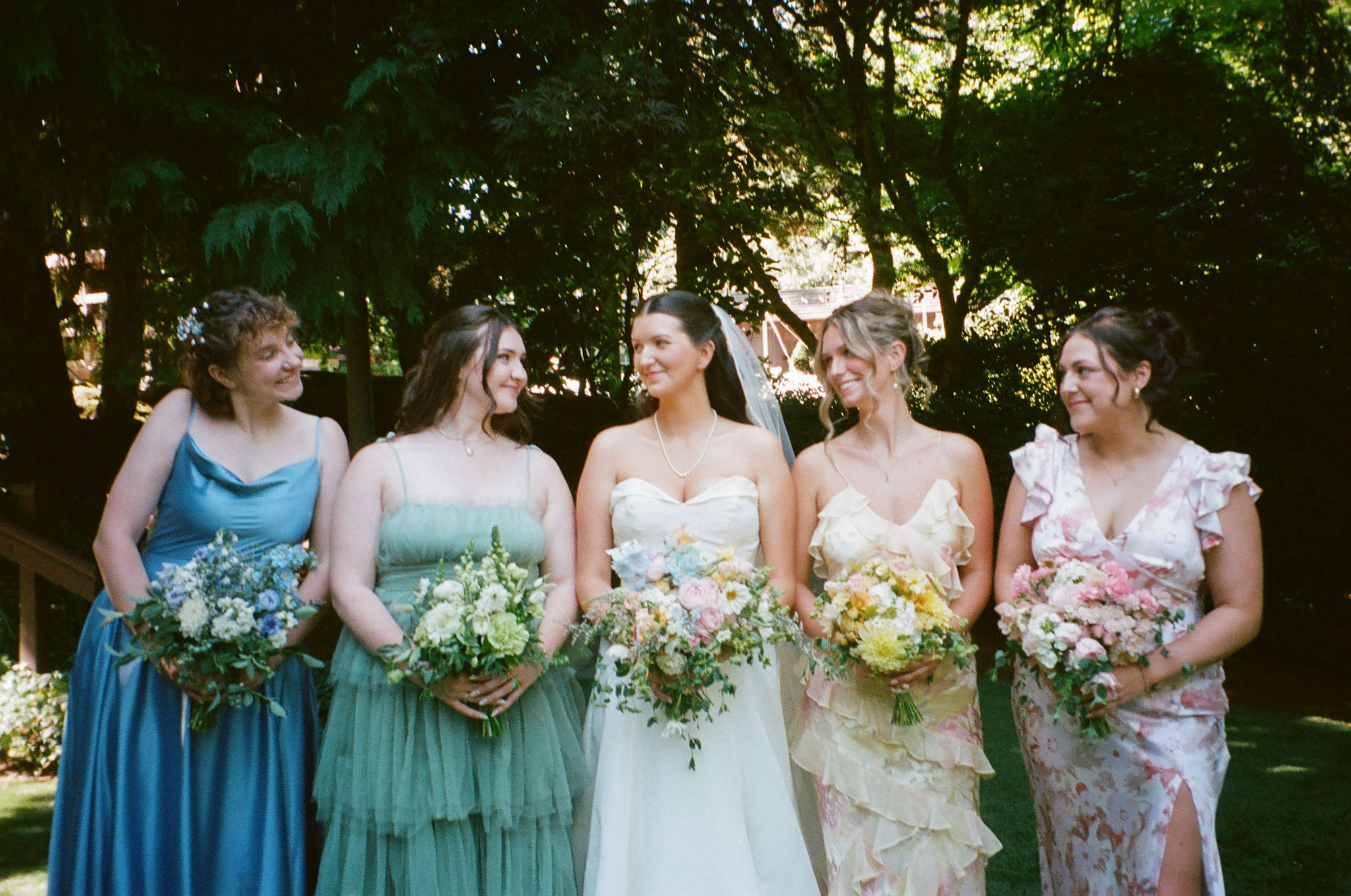 Film photo of bride and bridesmaids smiling at eachother