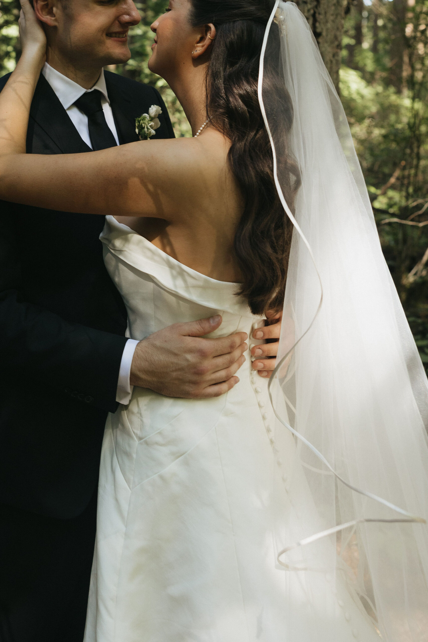 Bride and groom embracing eachother smiling as they hug