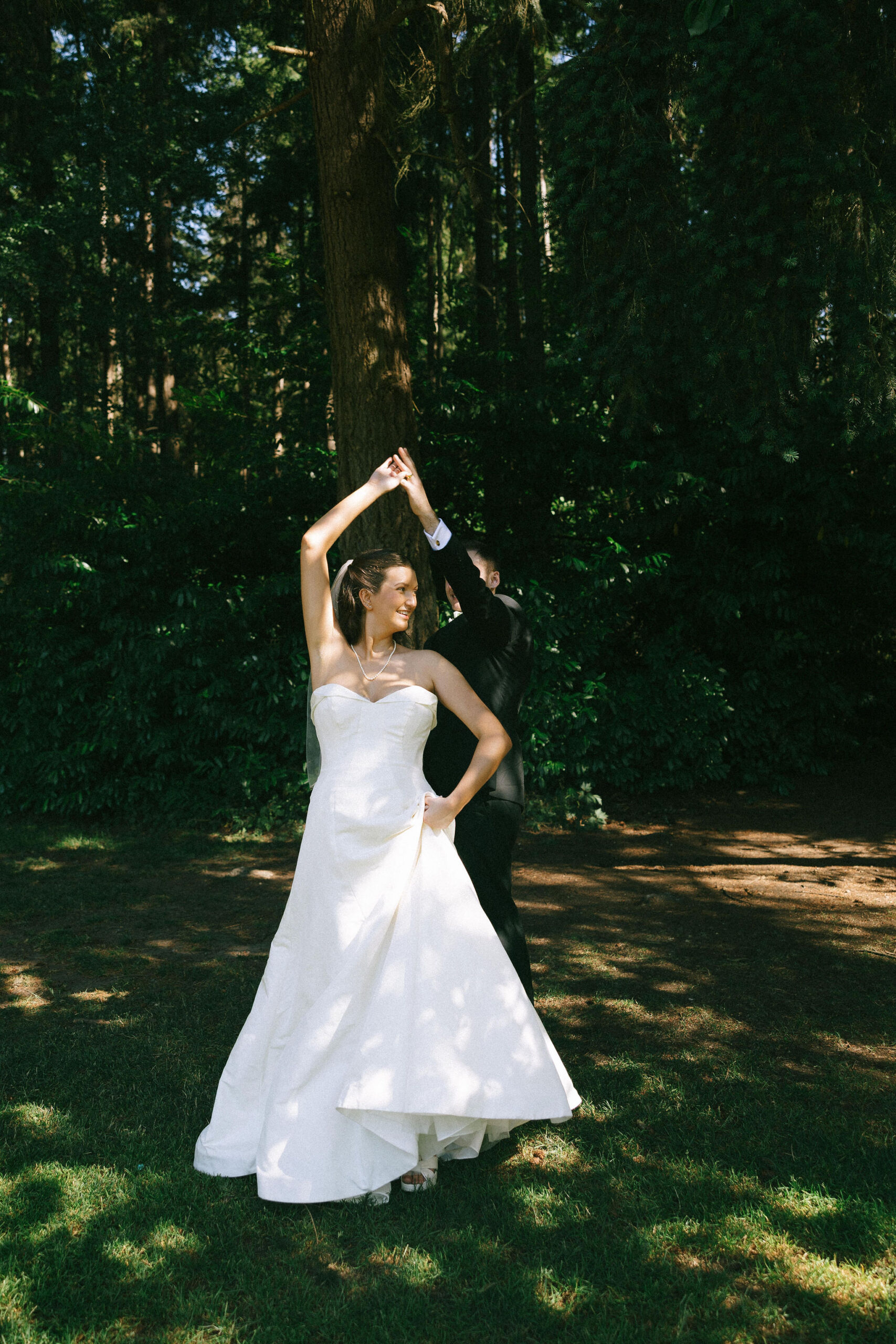 Bride and groom dancing in a field of grass at the Robinswood House