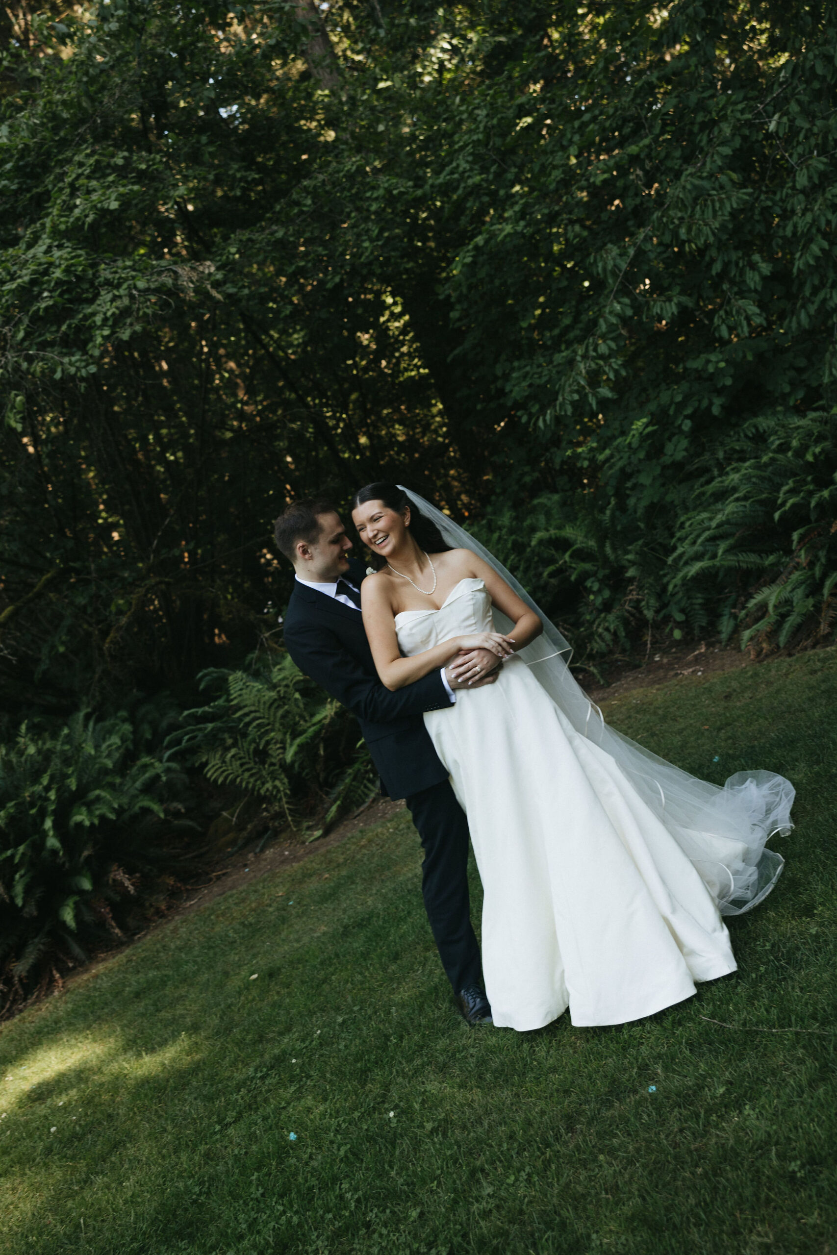 Bride and groom dancing in a field of grass at the Robinswood House