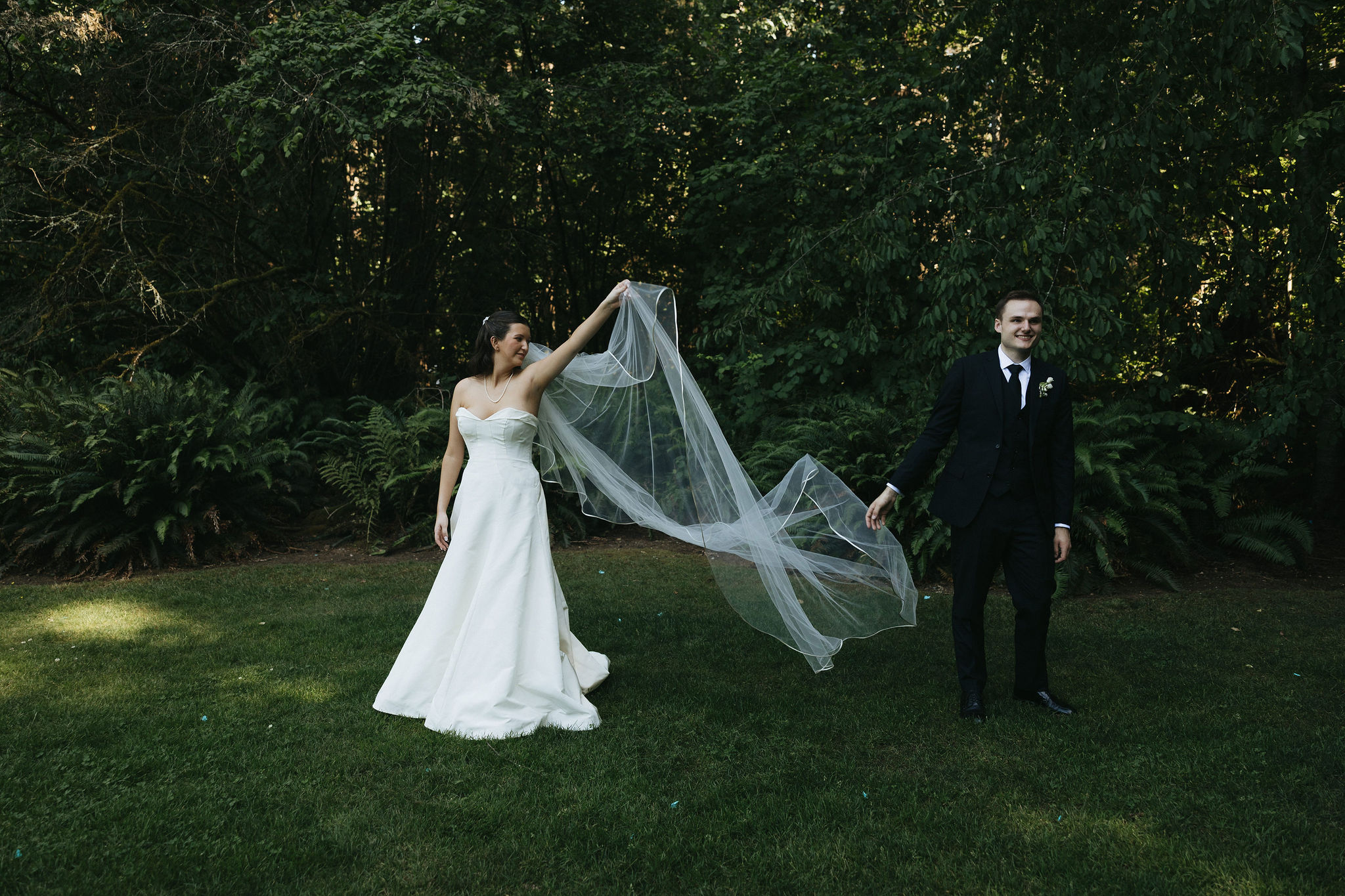 Bride and groom posing in a field of grass at the Robinswood House