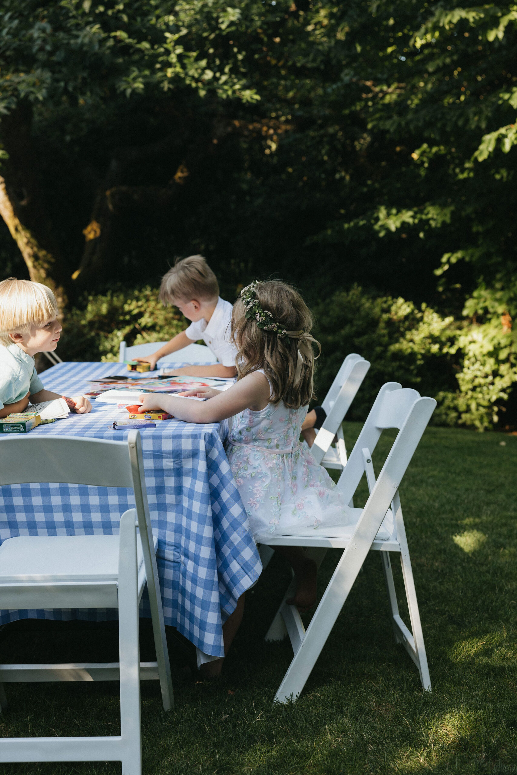 Little girl and boys drawing during the wedding reception with crayons