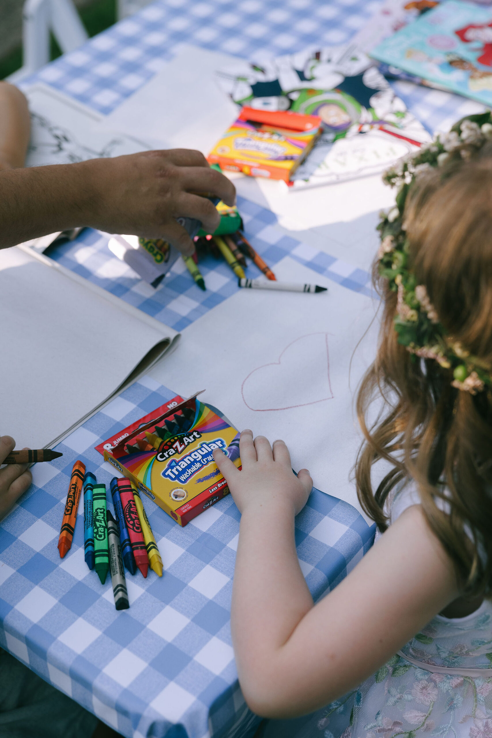 Little girl drawing during the wedding reception with crayons