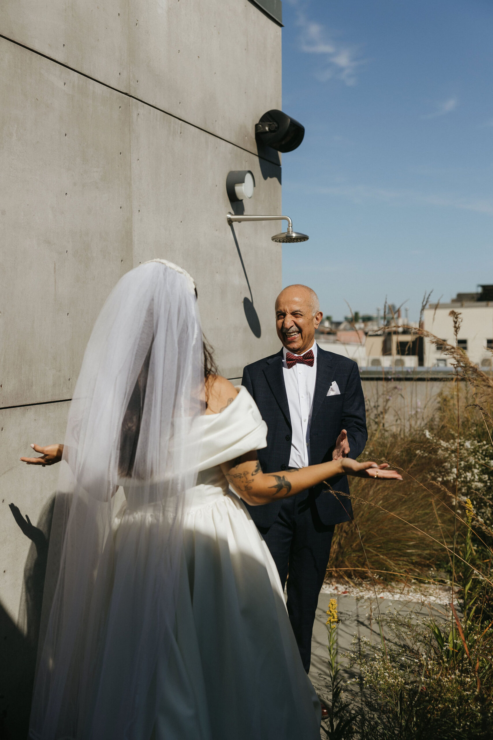 Father-daughter first look outdoors, the father smiling with joy at the sight of his daughter in her wedding dress.