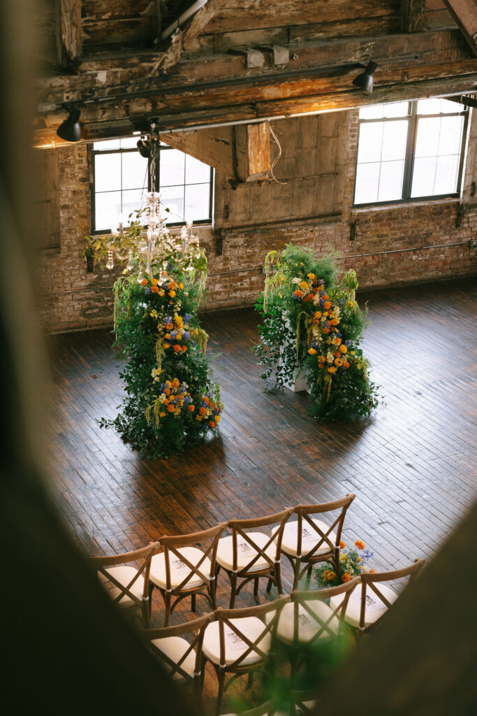 Beautiful floral arrangements decorating the ceremony space at Greenpoint Loft Wedding. 